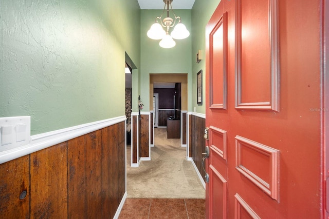 hall with a notable chandelier and light tile flooring