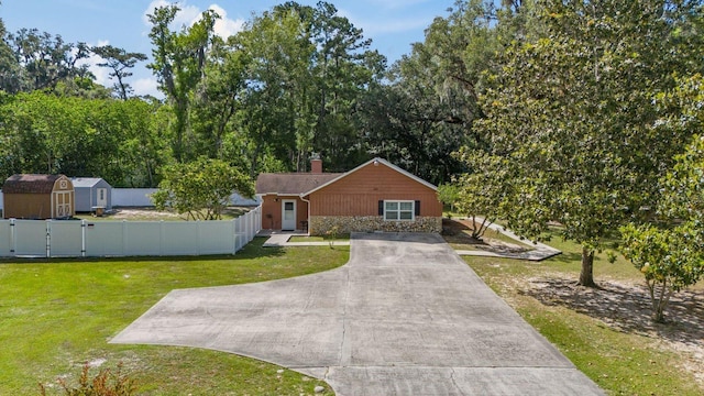 view of front of house with a front lawn and a storage unit