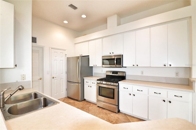 kitchen with white cabinets, light tile patterned flooring, sink, and appliances with stainless steel finishes