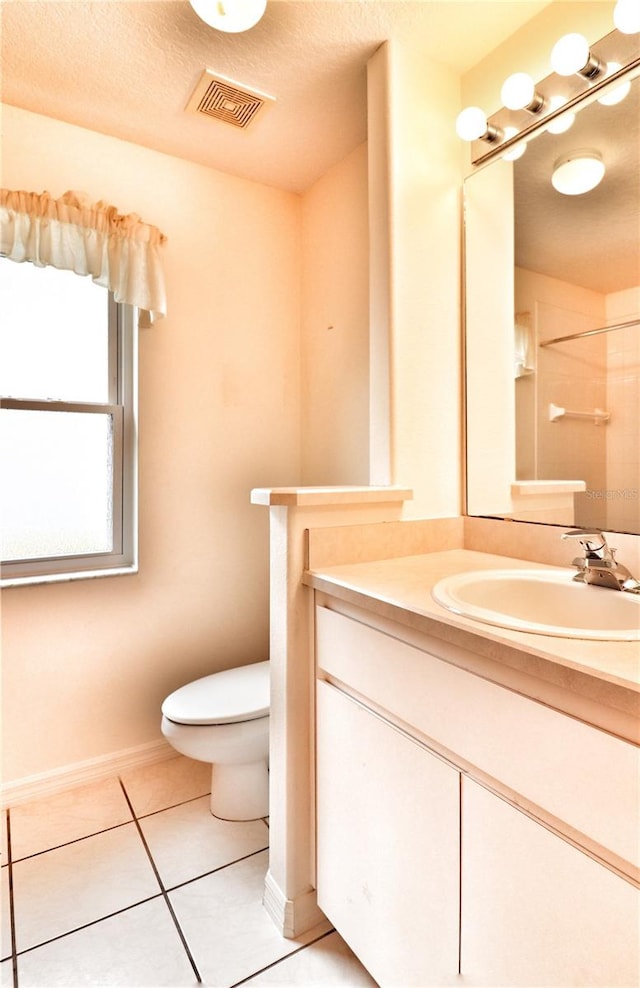 bathroom featuring toilet, a textured ceiling, vanity, and tile patterned floors