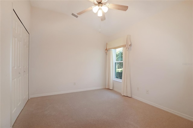 carpeted spare room featuring ceiling fan and lofted ceiling