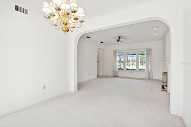 carpeted empty room featuring ceiling fan with notable chandelier