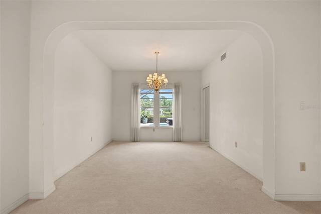 unfurnished room with light carpet and a notable chandelier