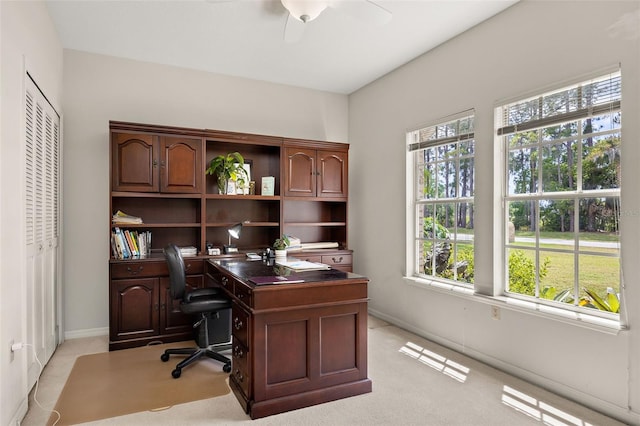 carpeted home office featuring ceiling fan