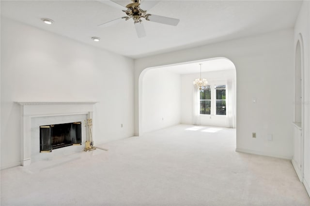 unfurnished living room with carpet, ceiling fan with notable chandelier, and a premium fireplace