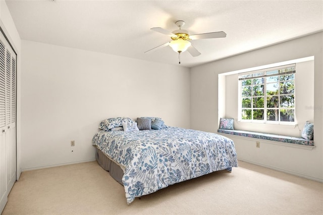 bedroom with light carpet, a closet, ceiling fan, and a textured ceiling