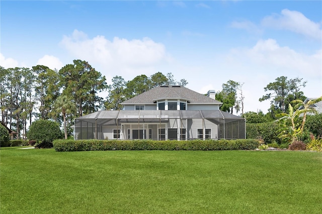 back of property with a yard and glass enclosure