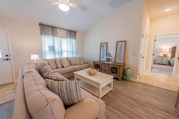 living room featuring ceiling fan, lofted ceiling, and light wood-type flooring