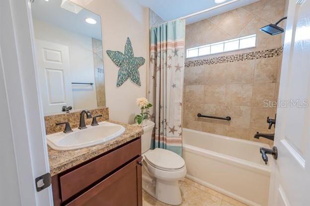 full bathroom featuring shower / bath combination with curtain, tile patterned floors, vanity, and toilet