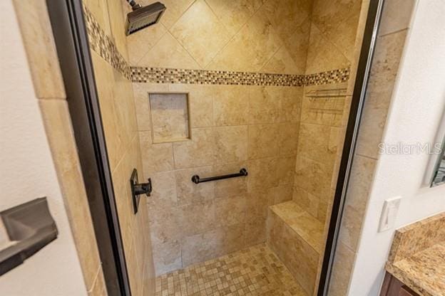 bathroom with vanity and tiled shower