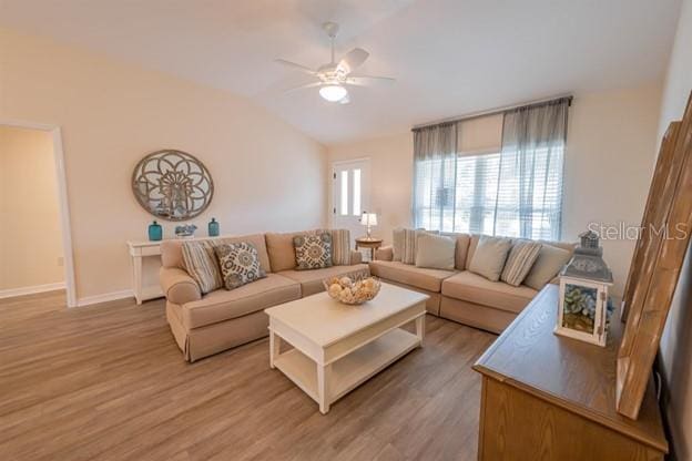 living room featuring ceiling fan, lofted ceiling, and wood-type flooring