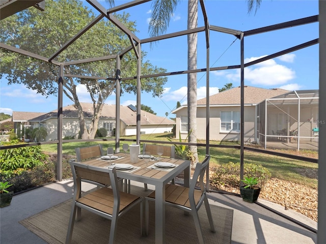 view of patio featuring a residential view, outdoor dining area, and glass enclosure