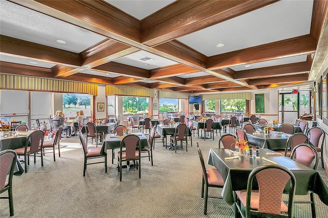 dining room with coffered ceiling, a wealth of natural light, beam ceiling, and light carpet