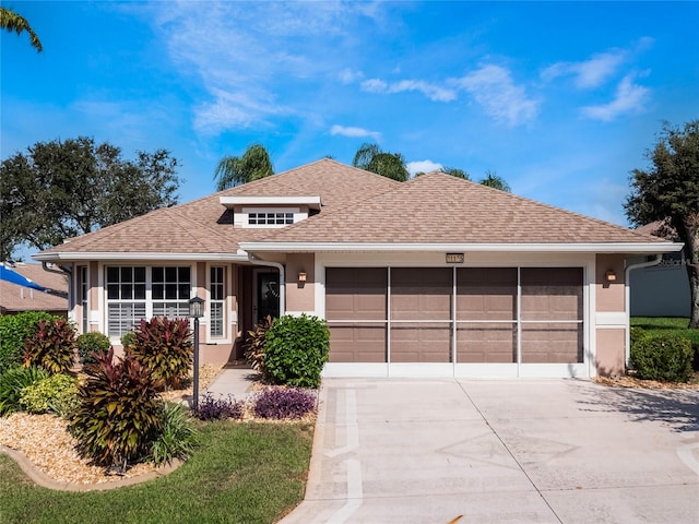 ranch-style house featuring a garage, roof with shingles, driveway, and stucco siding