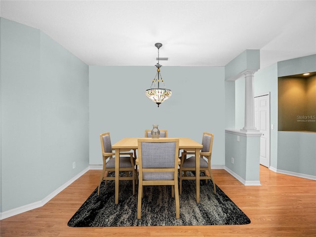 dining room featuring decorative columns, visible vents, light wood-style flooring, and baseboards