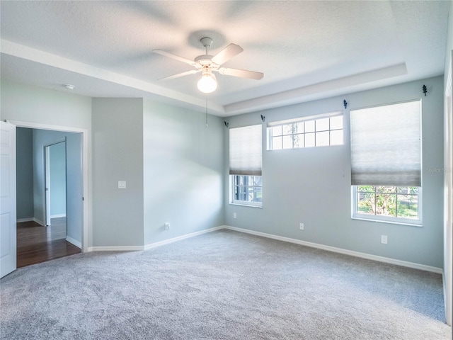 spare room with carpet floors, a ceiling fan, baseboards, and a textured ceiling