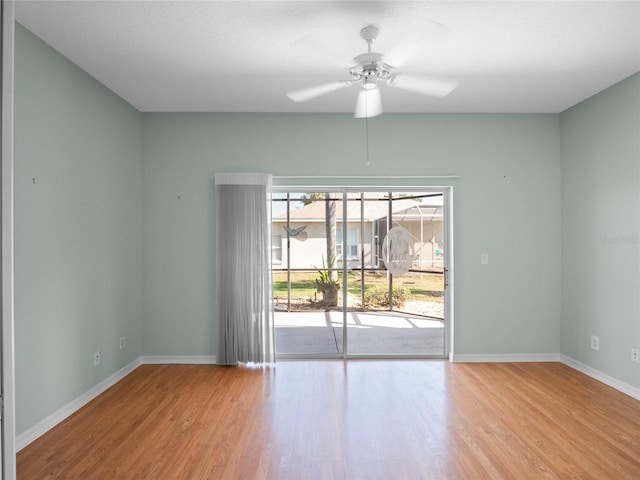 spare room featuring light wood-style floors, baseboards, and a ceiling fan