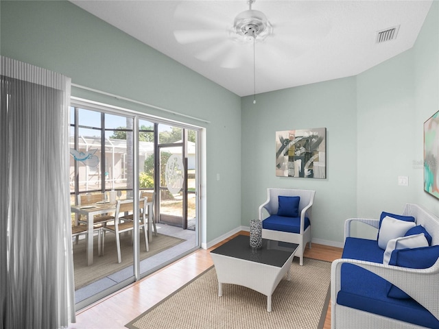 sitting room with ceiling fan, wood finished floors, visible vents, and baseboards