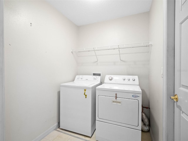 laundry area featuring laundry area, baseboards, and washer and clothes dryer