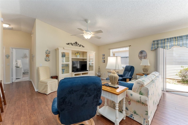 living room with a textured ceiling, ceiling fan, lofted ceiling, and wood-type flooring