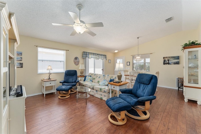 living room featuring vaulted ceiling, dark hardwood / wood-style flooring, and a healthy amount of sunlight