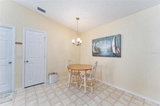 dining room featuring vaulted ceiling, a notable chandelier, and a textured ceiling