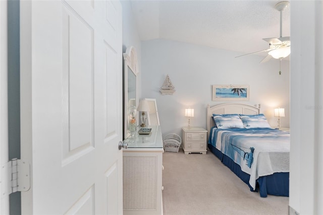 bedroom featuring vaulted ceiling, ceiling fan, a textured ceiling, and light colored carpet