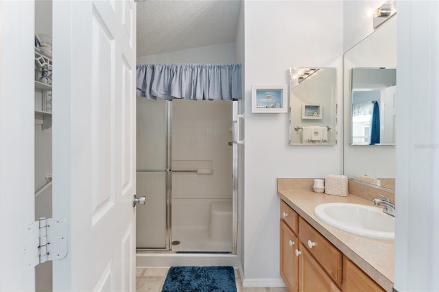 bathroom with walk in shower, vanity, tile patterned floors, and a textured ceiling