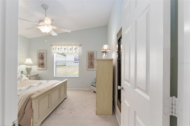 bedroom with light carpet, ceiling fan, and a textured ceiling