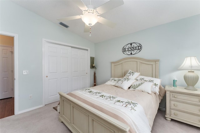 carpeted bedroom with vaulted ceiling, ceiling fan, and a closet