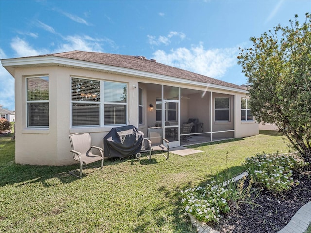 back of house with a sunroom and a lawn