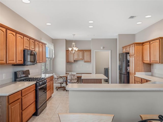 kitchen featuring stainless steel appliances, light tile patterned floors, an inviting chandelier, a kitchen island, and hanging light fixtures