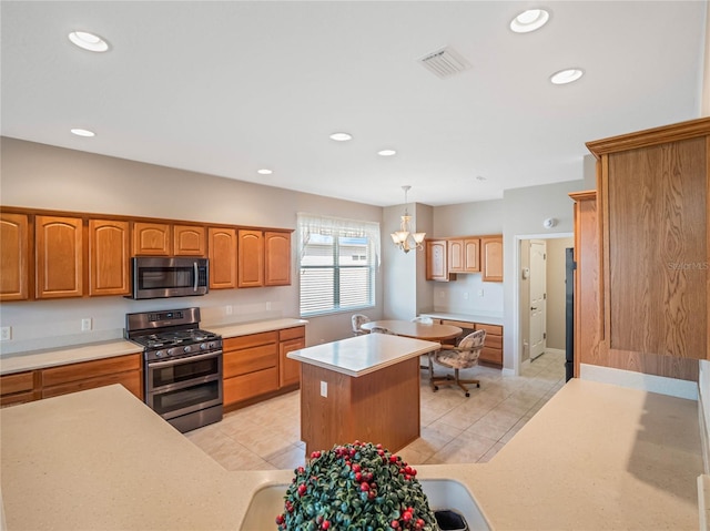 kitchen featuring pendant lighting, a center island, light tile patterned flooring, stainless steel appliances, and a chandelier