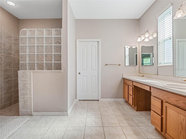 bathroom featuring tile patterned flooring, vanity, and tiled shower