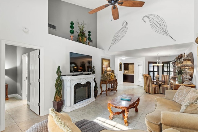 living room with a high ceiling, light tile patterned floors, and ceiling fan