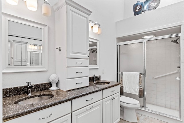 bathroom featuring vanity, toilet, a shower with shower door, and tile patterned flooring