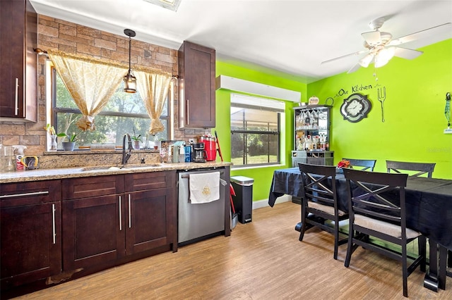 kitchen with plenty of natural light, tasteful backsplash, light wood-type flooring, and dishwasher