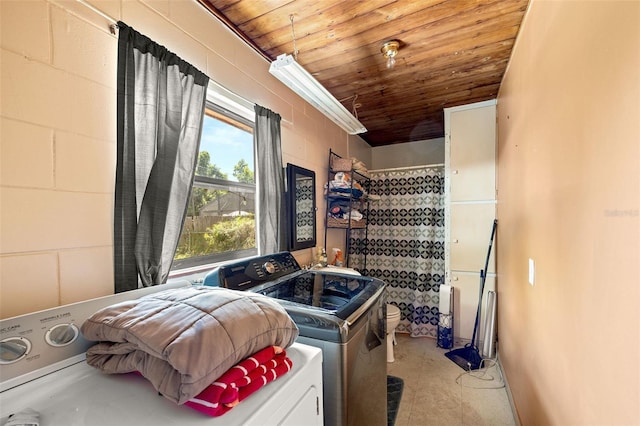 laundry room with wooden ceiling and washing machine and clothes dryer