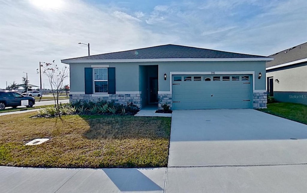 view of front of property with a garage and a front lawn