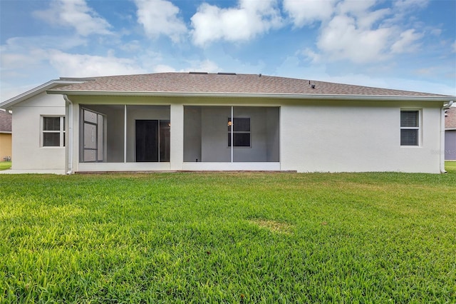 back of house featuring a sunroom and a lawn