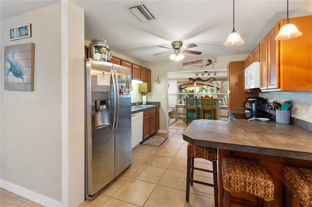 kitchen with sink, decorative light fixtures, light tile patterned floors, appliances with stainless steel finishes, and ceiling fan