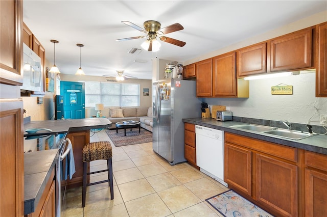 kitchen with sink, light tile patterned floors, ceiling fan, pendant lighting, and white appliances