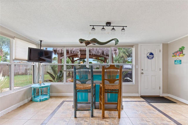 dining space with track lighting and a textured ceiling