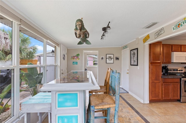 dining area with plenty of natural light, light tile patterned floors, and a textured ceiling