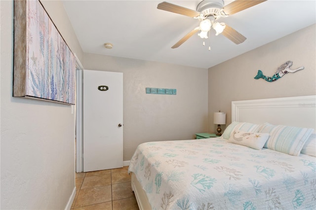 tiled bedroom featuring ceiling fan