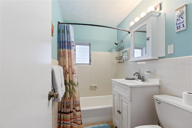 full bathroom featuring vanity, toilet, shower / bath combo with shower curtain, and tile walls