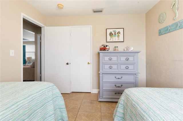 bedroom with light tile patterned floors and a closet