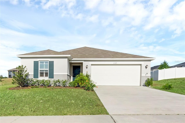 view of front of home with a front yard and a garage