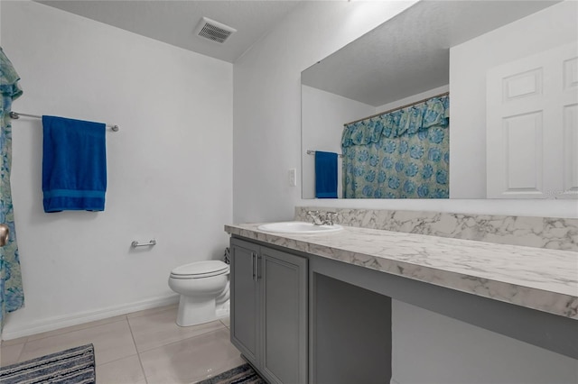 bathroom with tile patterned flooring, vanity, and toilet