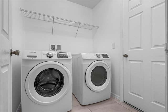 laundry area featuring light tile patterned floors and washer and clothes dryer